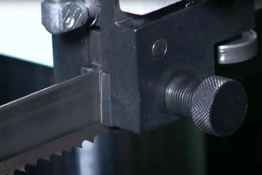 This image is a closeup which shows the blade guide system of a horizontal metal cutting bandsaw